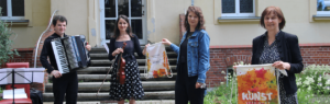 Anica Lexow und Dagmar Walter übergeben Stoffbeutel der Aktion Kunst auf Gutschein