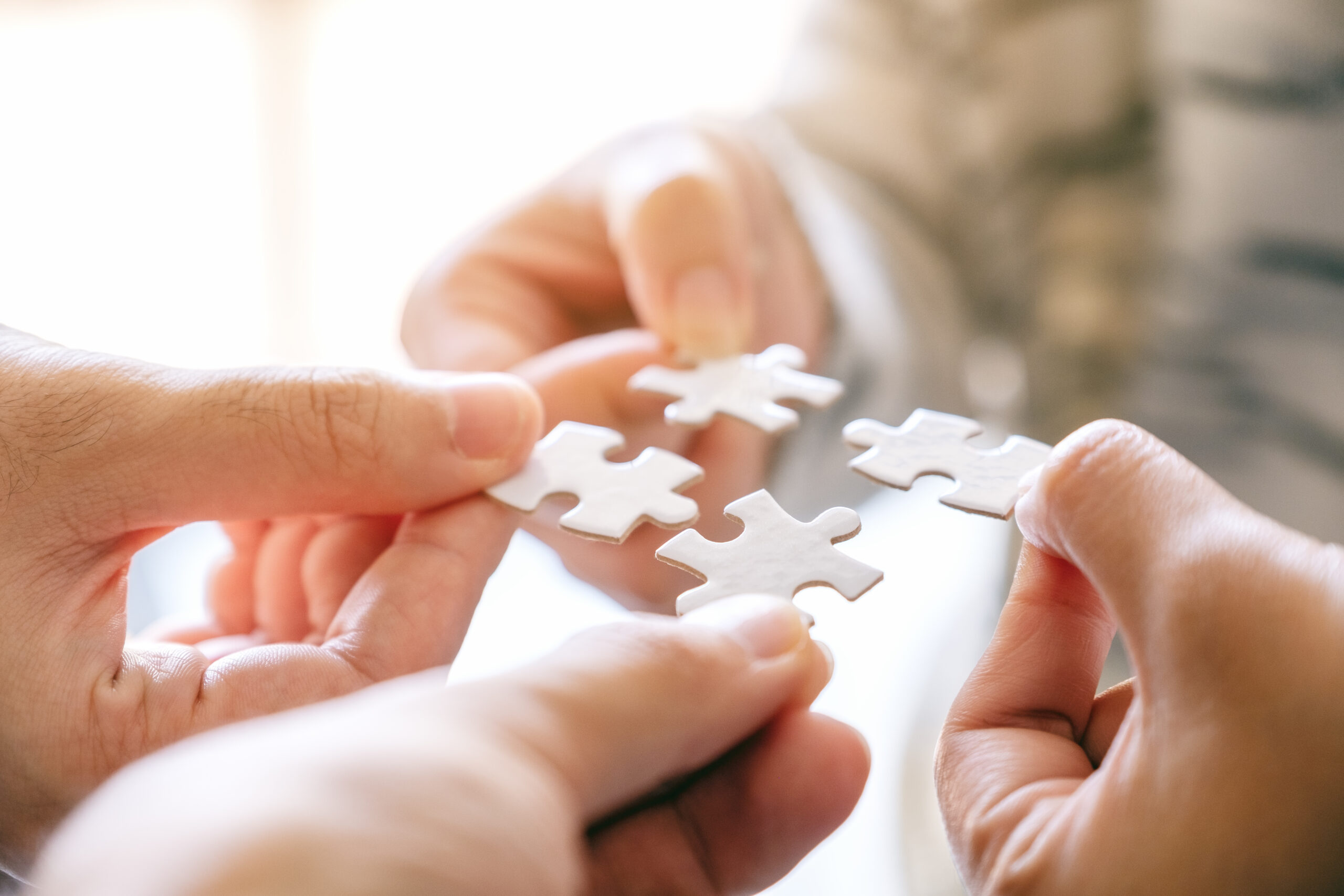 Closeup image of many people holding and putting a piece of whit